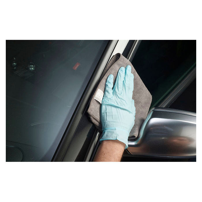 Hånd med handske påfører Autoglym Plastic & Trim Conditioner på bilens trim