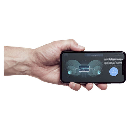 Hånd holder telefon med Alpine OPTIM8 DSP-app til lydmåling i bil