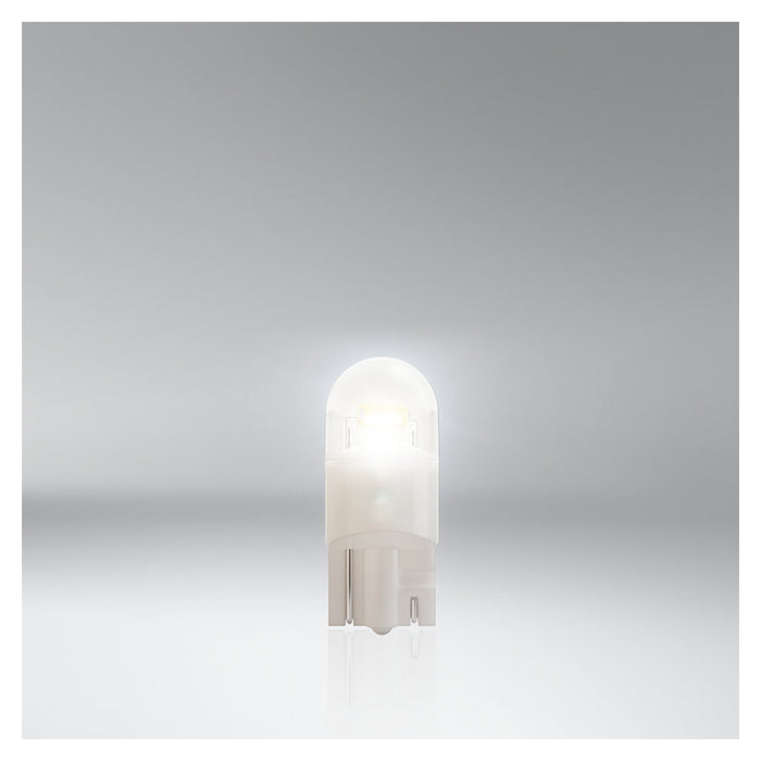 Osram Night Breaker W5W LED pære lyser hvidt på grå baggrund.