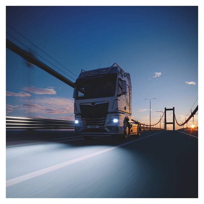 Orang Truckstar H7 LED pærer på lastbil over bro ved solnedgang