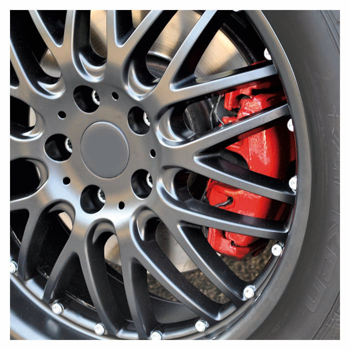 Nærbillede af bilhjul med sorte fælge og røde bremsecalipere