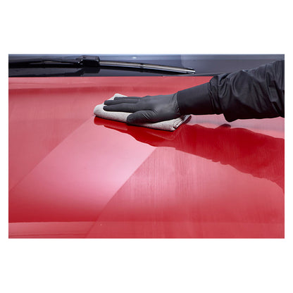 Hånd polerer en rød bil med mikrofiberklud og Autoglym Radiant Wax Polish for glans.