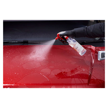 Person sprayer Autoglym Autogloss Rinse skyllevoks på rød bil for glans og vandafvisning