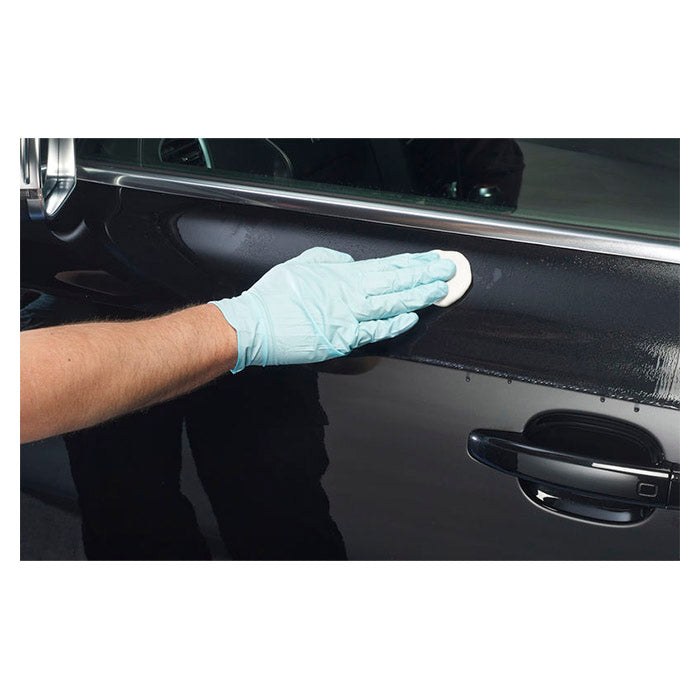 Hånd med handske polerer sort bils lak med Autoglym Fast Shine & Lube