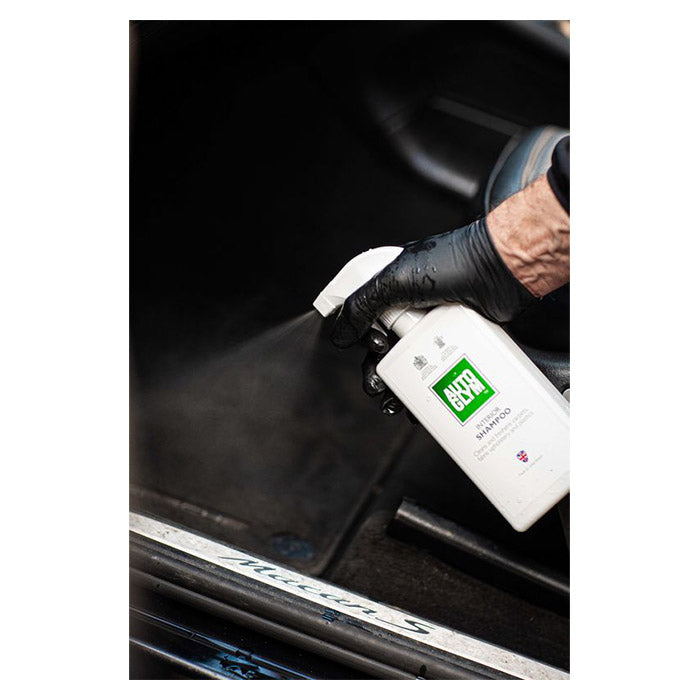Autoglym interiørrens sprayes på bilens tæppe for effektiv rengøring.