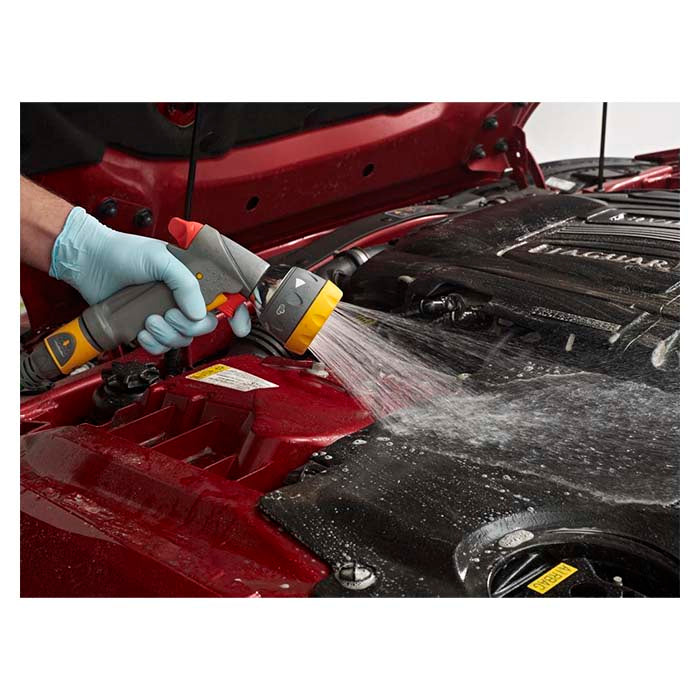 Person vasker motorrum med vandslange og Autoglym Engine & Machine Cleaner, motorrens