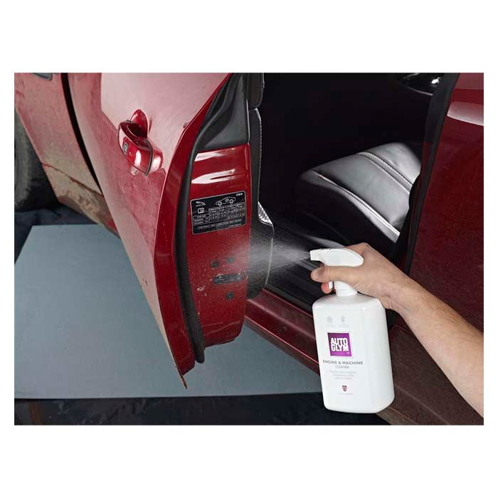 Person sprøjter Autoglym Engine & Machine Cleaner på en rød bildør.