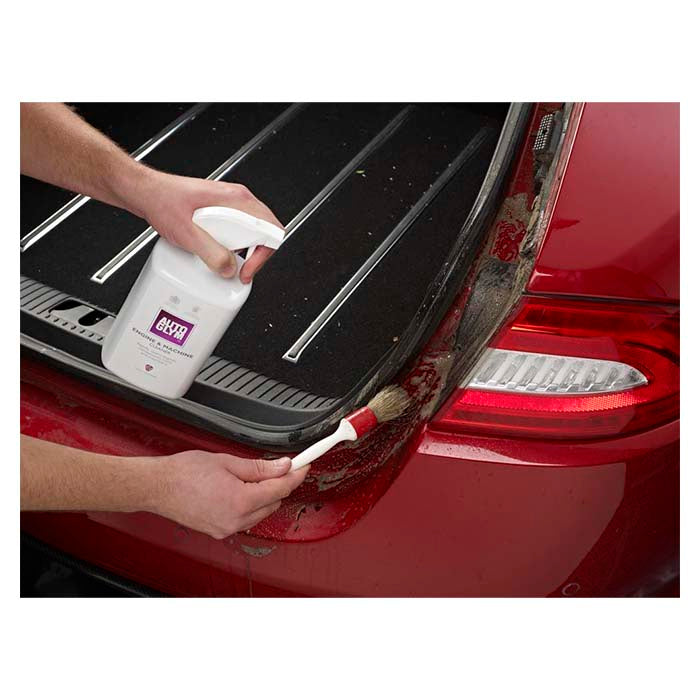 Autoglym Engine Machine Cleaner sprøjtes og børstes på snavset bilbagagerum.