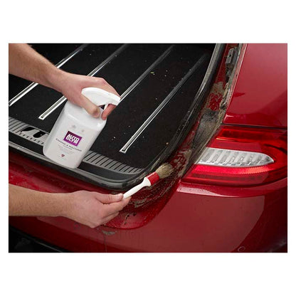 Autoglym Engine Machine Cleaner sprøjtes og børstes på snavset bilbagagerum.
