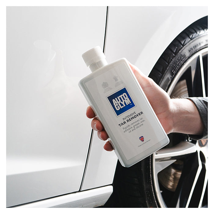 Autoglym Intensive Tar Remover flaske holdes mod hvid bil og hjul