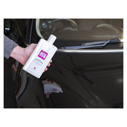 Autoglym Paint Renovator flaske holdt over en skinnende billak, klar til brug