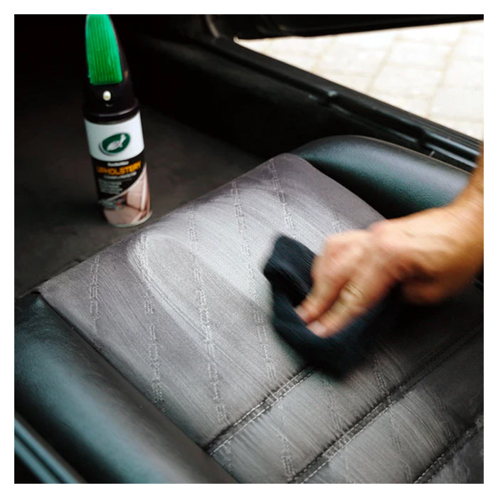 Hånd rengører bilsæde med Turtle Wax tekstilrens og mikrofiberklud