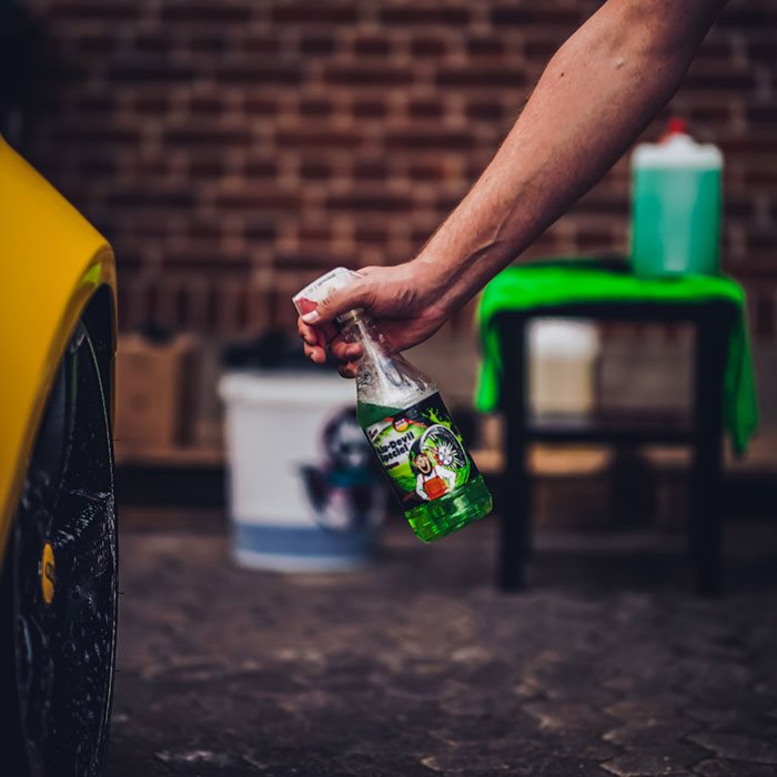 Tuga Alu-Devil Speciel fælgrens sprøjtes på en gul bilfælg foran en murstensvæg