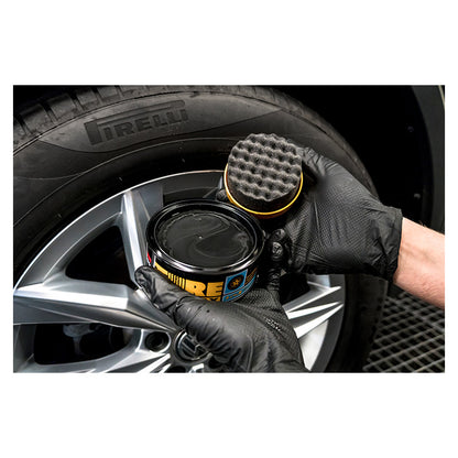 Soft99 Tire Black Wax påføres dækket med en svamp for en dyb sort finish
