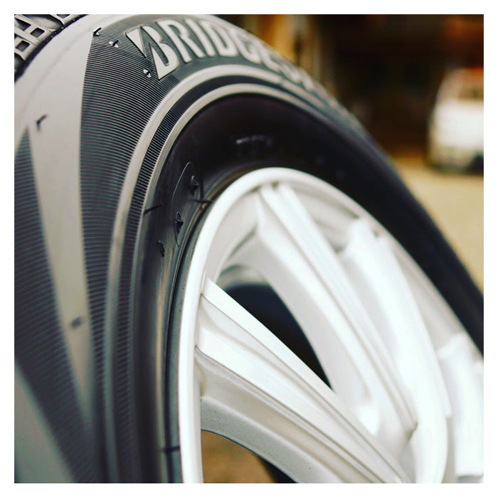 Soft99 Tire Black Wax på et Bridgestone-dæk med hvid fælg, der glinser