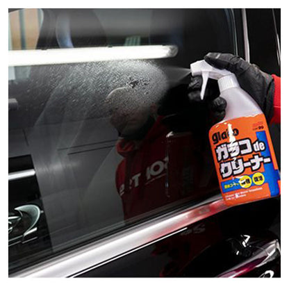 Person sprøjter Soft99 Glaco De Cleaner på bilrude med handsker på