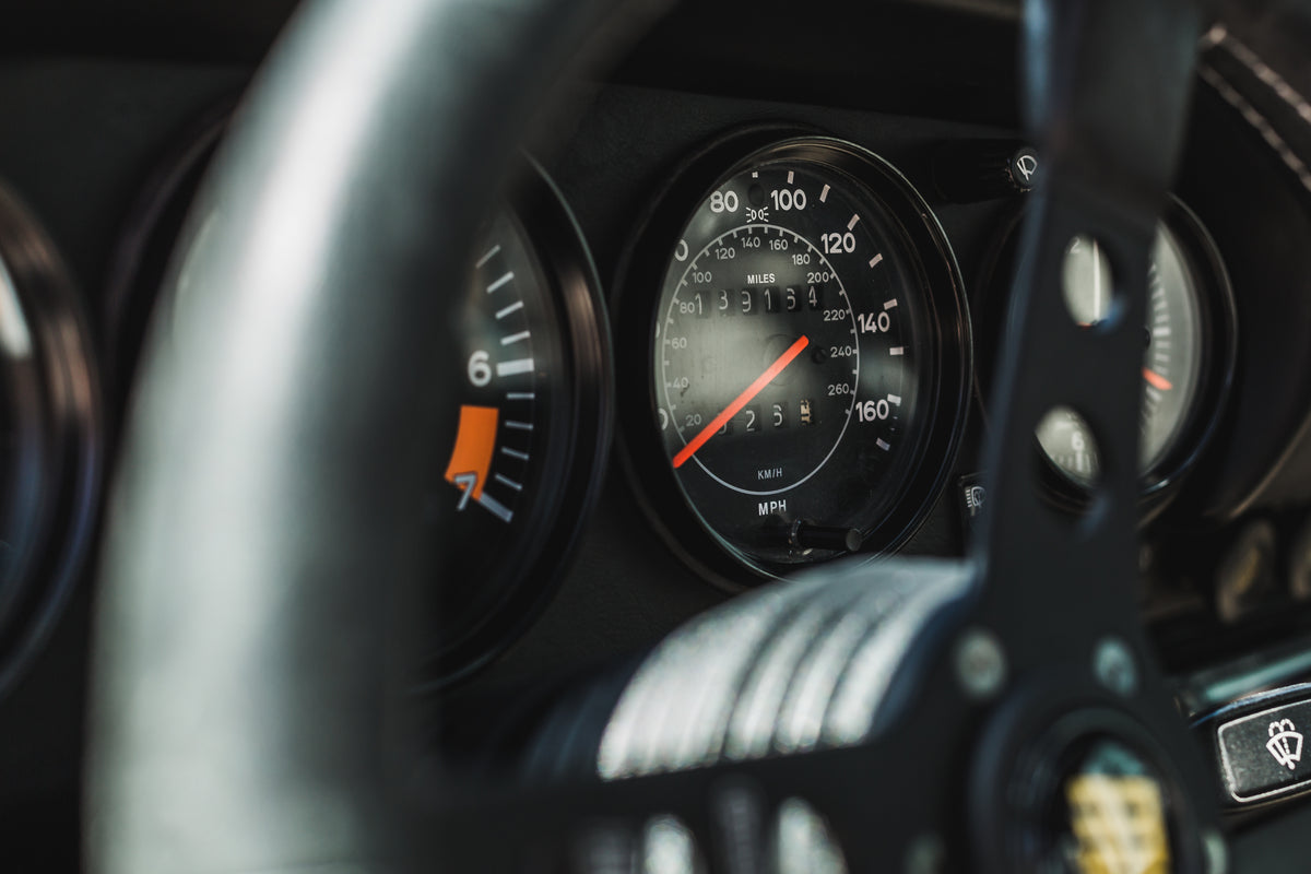 Vintage bil instrumentbræt med speedometer og omdrejningstæller, nærratset